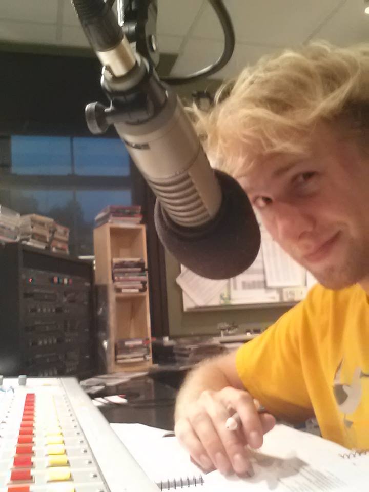 A radio DJ speaking into a studio microphone